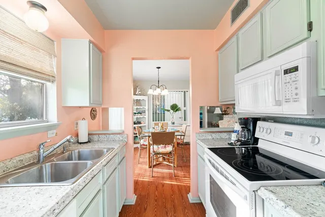 a kitchen with a stove a sink a refrigerator and cabinets