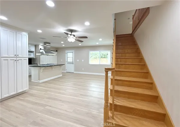 an empty room with windows and chandelier fan