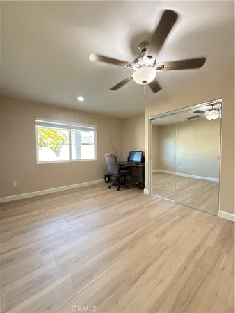 an empty room with a ceiling fan and window