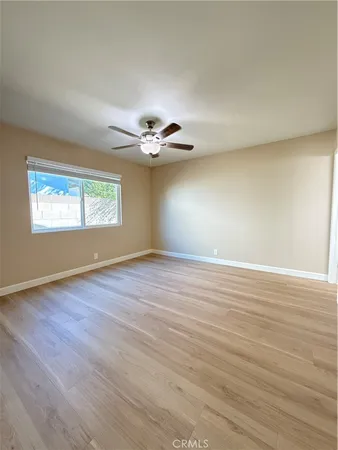 an empty room with windows and ceiling fan