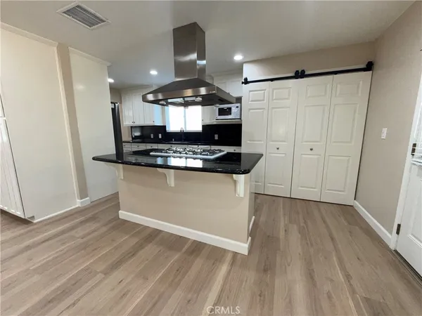 a kitchen with stainless steel appliances kitchen island granite countertop a stove a sink and a microwave