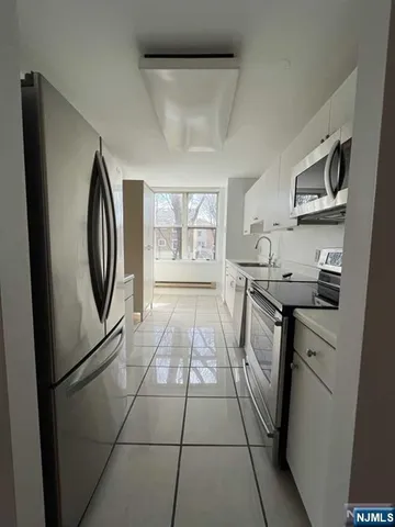 a kitchen with stainless steel appliances granite countertop a refrigerator a stove a sink and a microwave