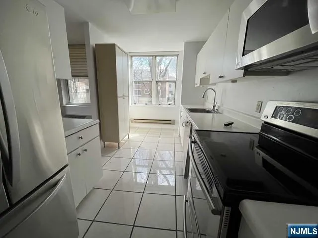 a kitchen with a stove and white cabinets