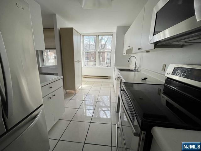 200 Grand Cove Way, Unit 2A Edgewater, NJ 07020 - Photo 7 of 12 a kitchen with a stove and white cabinets