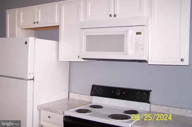 a kitchen with a white cabinets and white appliances