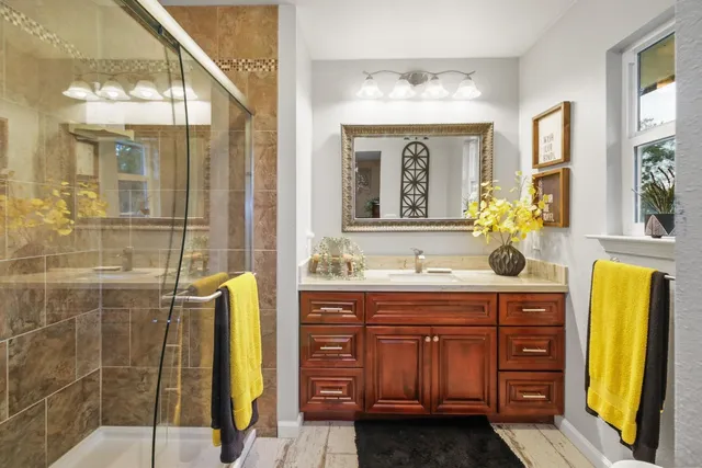 a spacious bathroom with a granite countertop sink mirror and shower