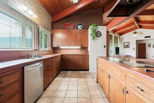 a large white kitchen with a large window and cabinets