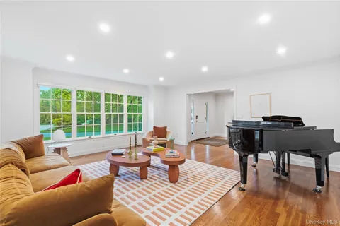 a living room with furniture chandelier and a large window
