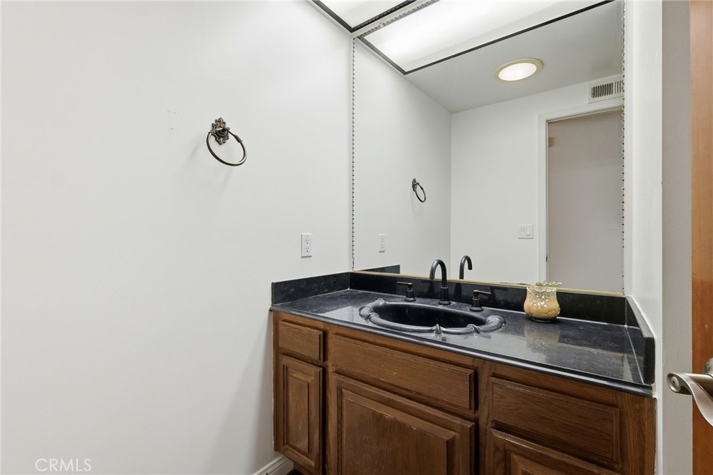 18233 Charlton Lane Porter Ranch, CA 91326 - Photo 14 of 40 a bathroom with a granite countertop sink and a mirror