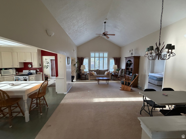 10000 North 6730th East Spring City, UT 84662 - Photo 12 of 31 Vaulted ceilings define this open living space featuring carpet flooring and ample natural light through shuttered windows