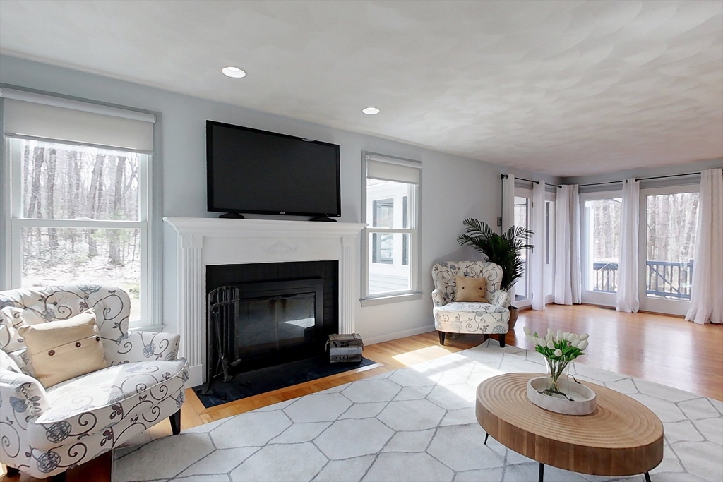 4 Wilderness Way Pepperell, MA 01463 - Photo 11 of 42 a living room with furniture a fireplace and a flat screen tv