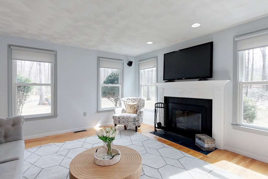 4 Wilderness Way Pepperell, MA 01463 - Photo 12 of 42 a living room with furniture a flat screen tv and a fireplace