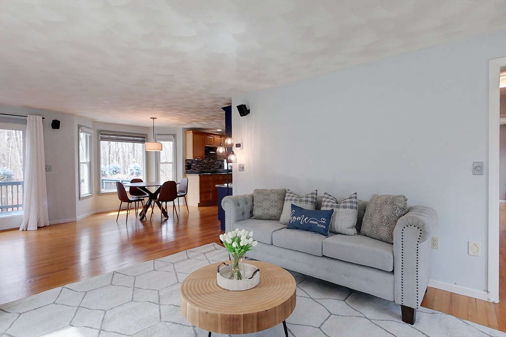 4 Wilderness Way Pepperell, MA 01463 - Photo 14 of 42 a living room with furniture and a dining table with wooden floor