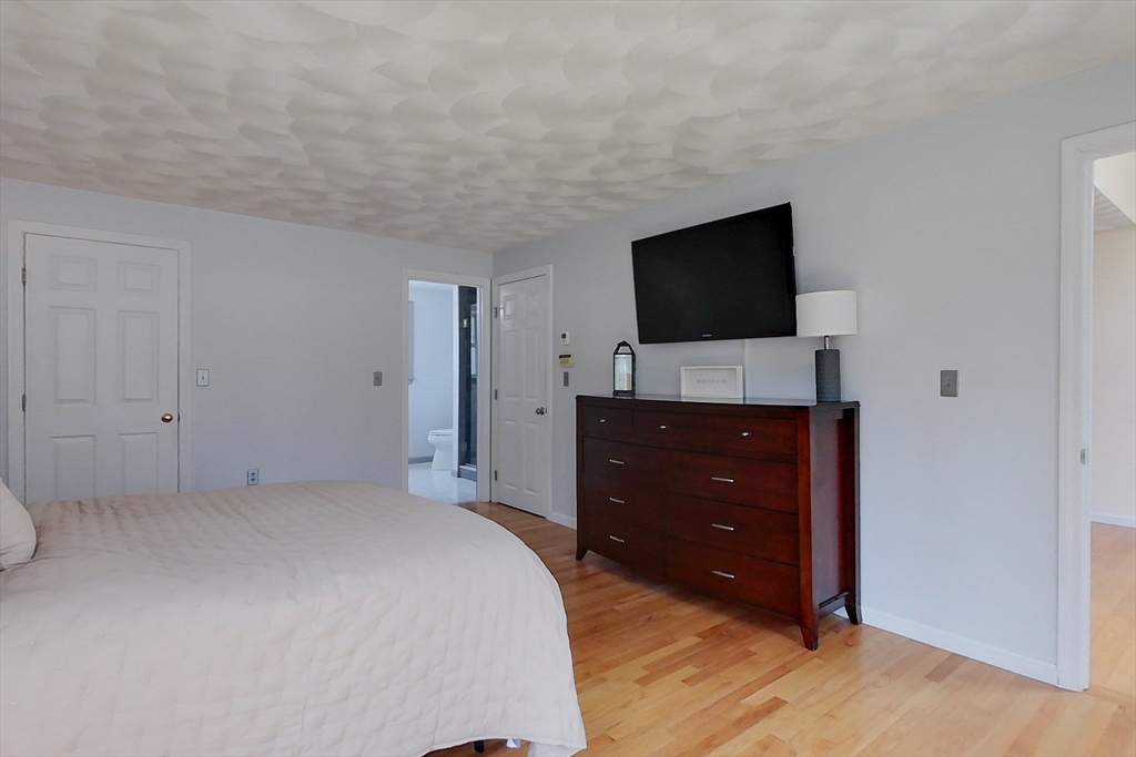 4 Wilderness Way Pepperell, MA 01463 - Photo 20 of 42 a bedroom with a bed and a flat screen tv