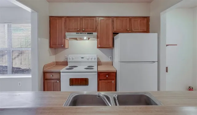 a kitchen with a refrigerator sink and cabinets