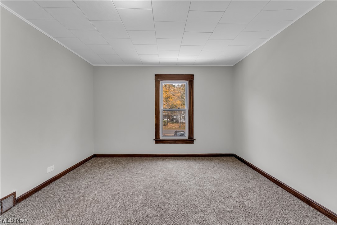 6184 Turney Road Cleveland, OH 44125 - Photo 14 of 28 Empty room with light carpet and crown molding