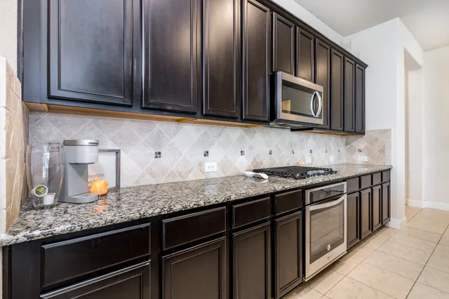 a kitchen with stainless steel appliances granite countertop a sink stove and microwave