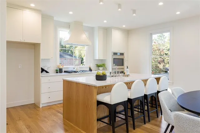 a kitchen with a dining table chairs and white cabinets