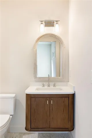 a bathroom with a sink a toilet and mirror