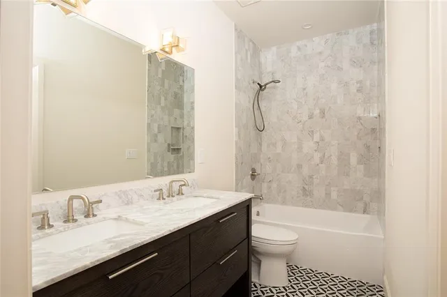 a bathroom with a granite countertop sink toilet and shower