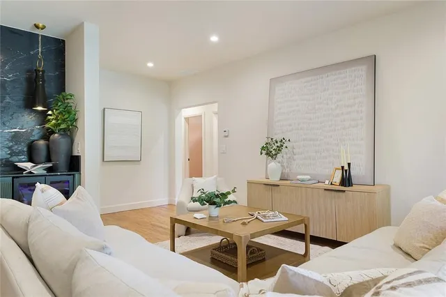 a living room with furniture a potted plant and a table