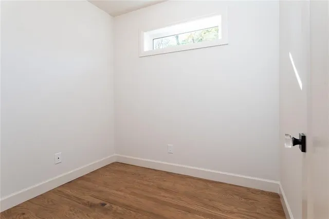 a view of a small space with wooden floor and a window