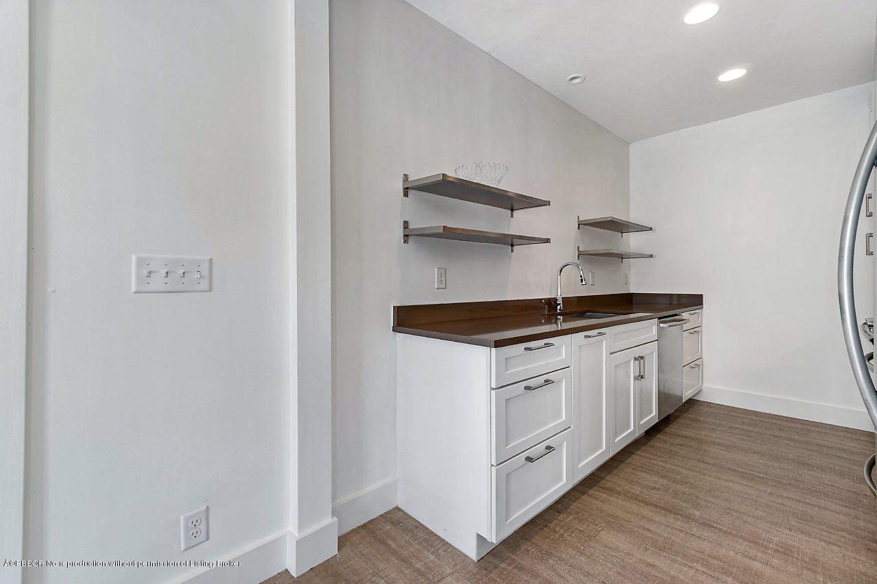 231 Dyer Road West Palm Beach, FL 33405 - Photo 33 of 45 a kitchen with stainless steel appliances granite countertop white cabinets and wooden floor