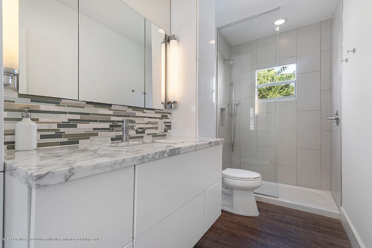 231 Dyer Road West Palm Beach, FL 33405 - Photo 38 of 45 a bathroom with a granite countertop toilet a sink and mirror