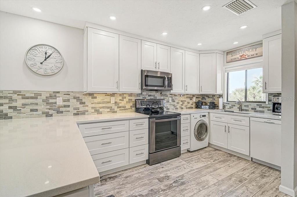 1624 Stickney Point Road, Unit 1624301 Sarasota, FL 34231 - Photo 11 of 55 a kitchen with granite countertop white cabinets and stainless steel appliances