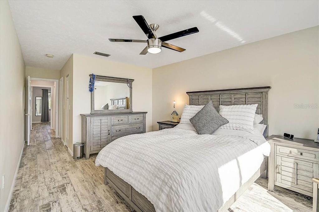 1624 Stickney Point Road, Unit 1624301 Sarasota, FL 34231 - Photo 19 of 55 a bedroom with a bed and a ceiling fan