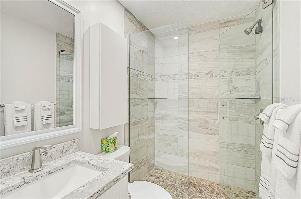 1624 Stickney Point Road, Unit 1624301 Sarasota, FL 34231 - Photo 20 of 55 a bathroom with a sink vanity mirror and shower