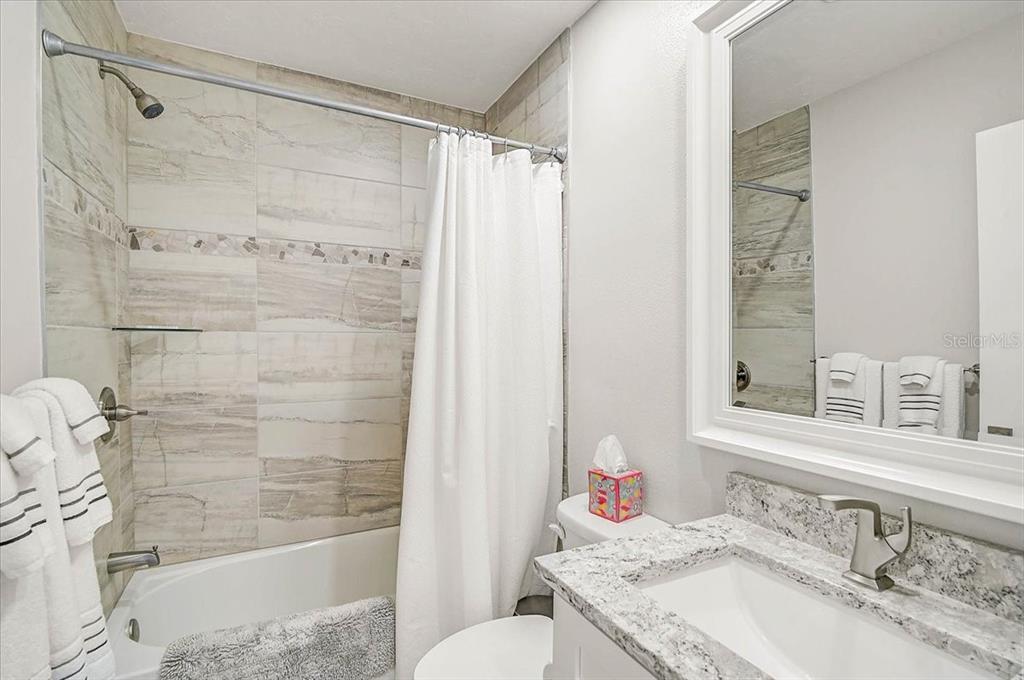 1624 Stickney Point Road, Unit 1624301 Sarasota, FL 34231 - Photo 23 of 55 a bathroom with a granite countertop sink toilet and shower