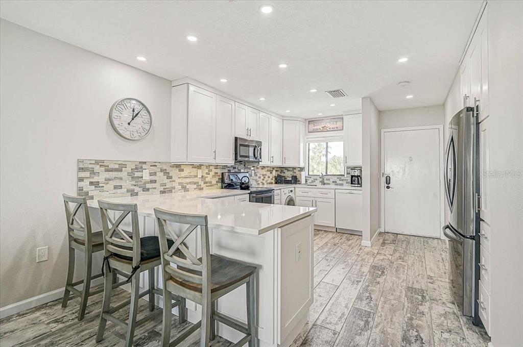 1624 Stickney Point Road, Unit 1624301 Sarasota, FL 34231 - Photo 6 of 55 a kitchen with cabinets and stainless steel appliances