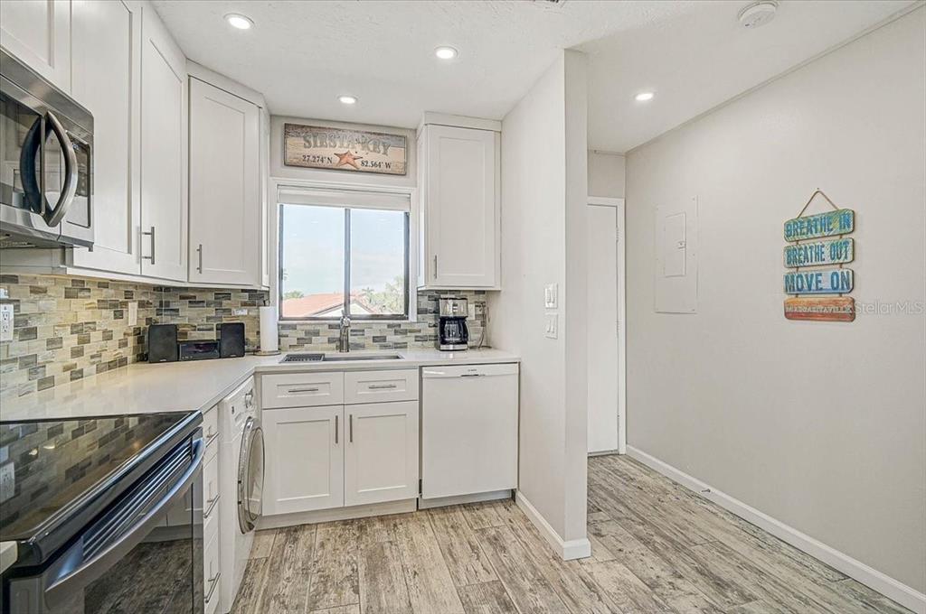 1624 Stickney Point Road, Unit 1624301 Sarasota, FL 34231 - Photo 7 of 55 a kitchen with granite countertop white cabinets and white appliances