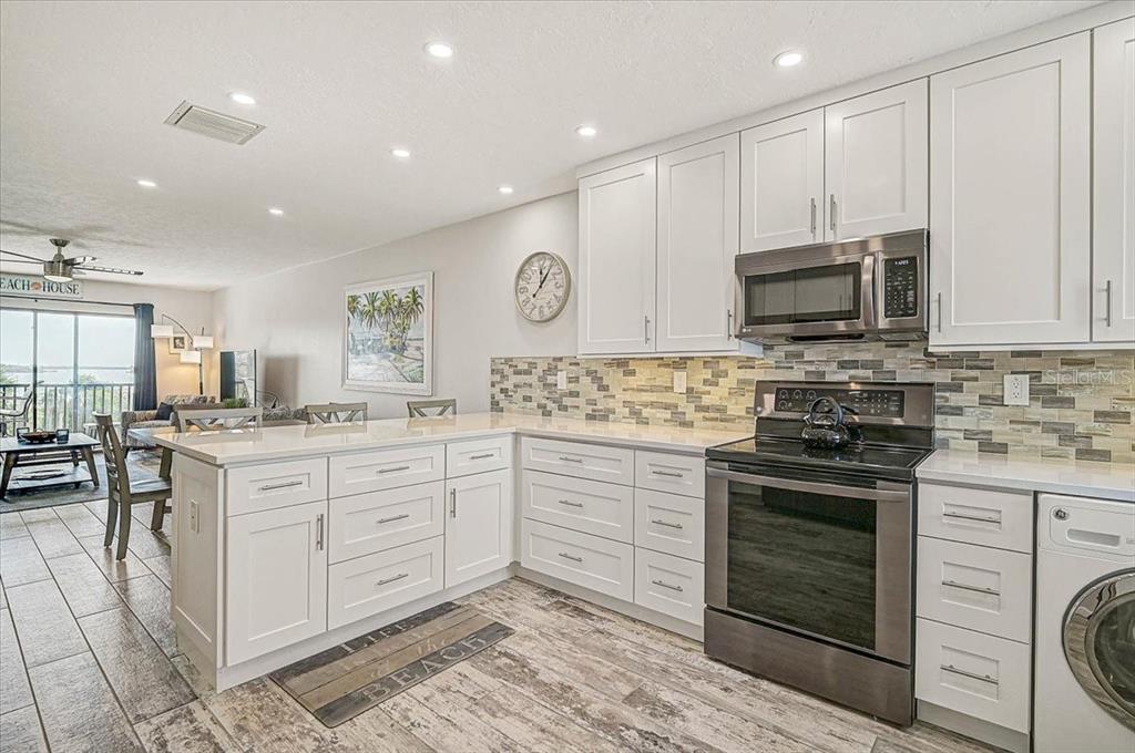1624 Stickney Point Road, Unit 1624301 Sarasota, FL 34231 - Photo 9 of 55 a kitchen with granite countertop a stove top oven sink and cabinets
