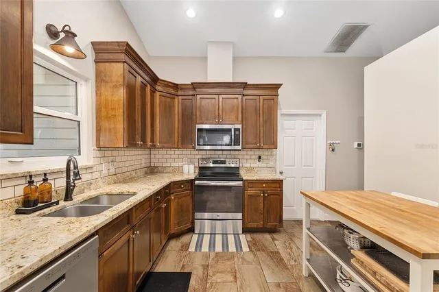 a kitchen with stainless steel appliances a sink stove and microwave