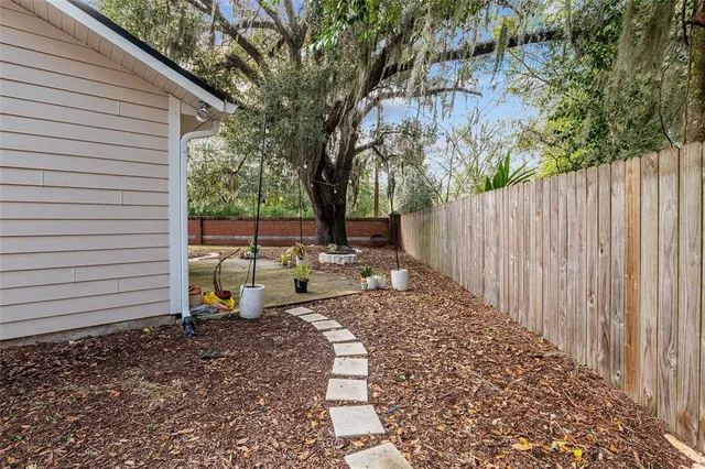 a view of a house with backyard and a tree