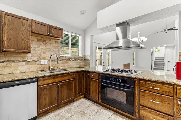 a kitchen with stainless steel appliances granite countertop a sink stove and cabinets