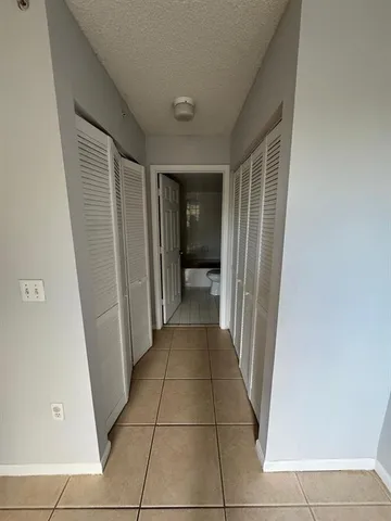 a view of a hallway with wooden floor and a living room