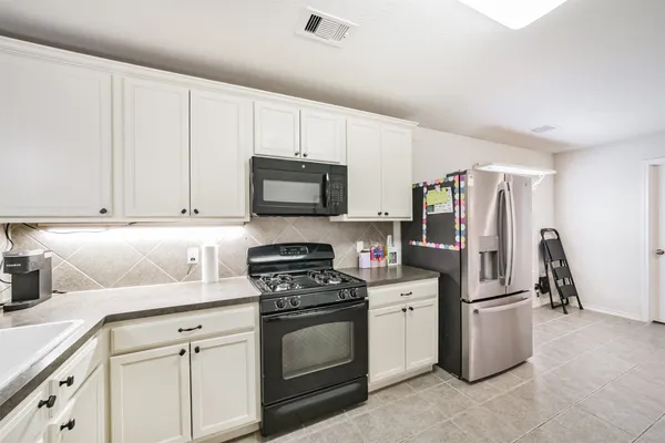a large white kitchen with stainless steel appliances