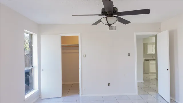 a view of a hallway with a chandelier fan and a closet