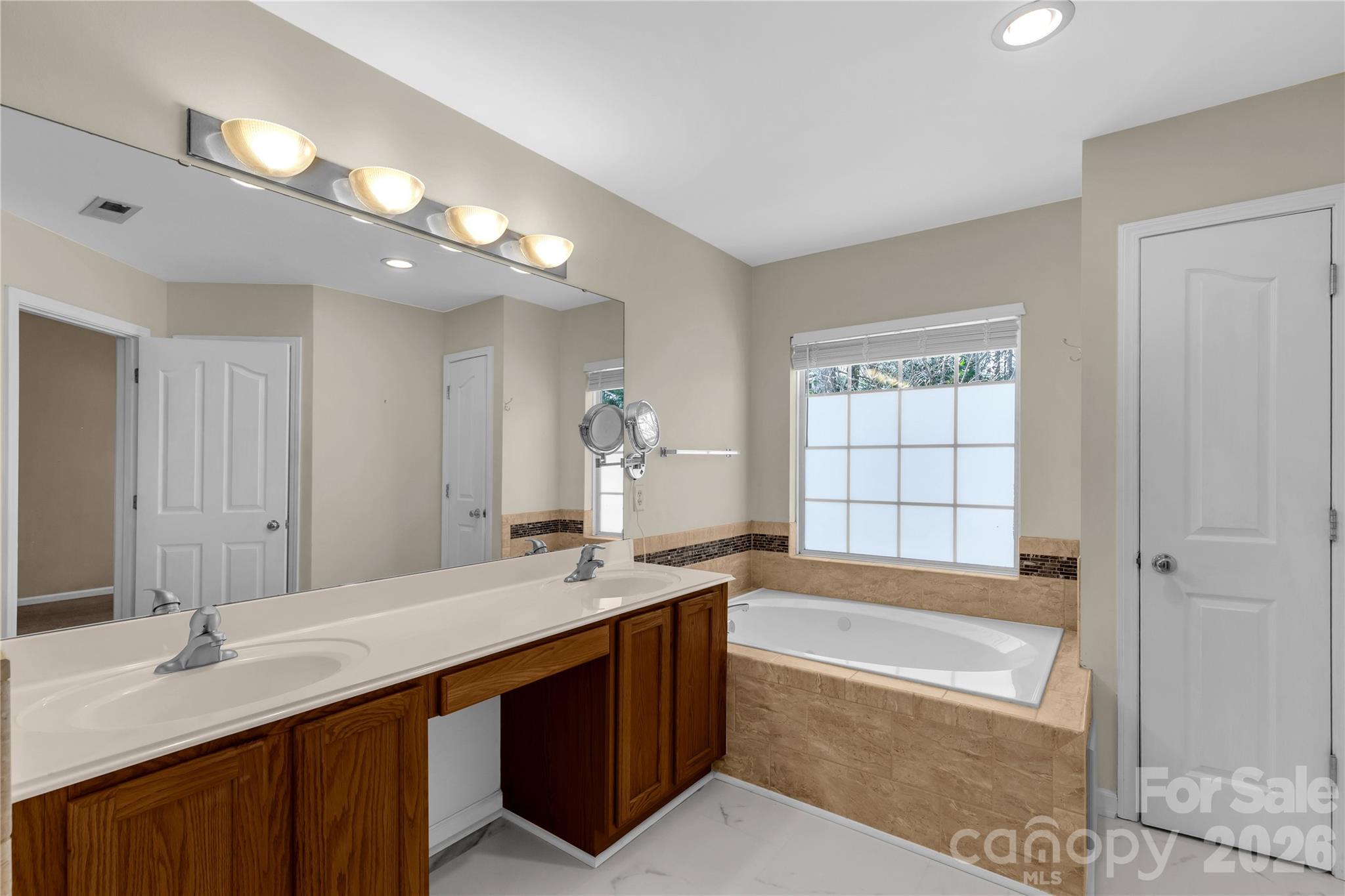 1644 Spandril Lane Fort Mill, SC 29708 - Photo 27 of 32 a bathroom with a sink double vanity granite tub shower and a mirror