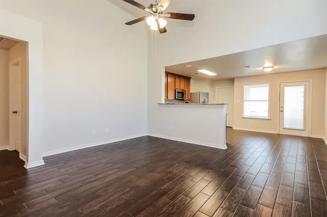 a view of a livingroom with wooden floor and a ceiling fan