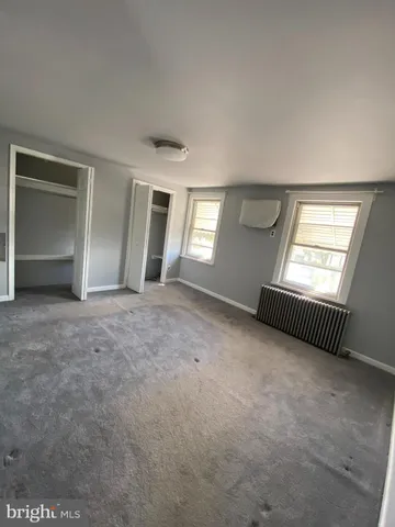 an empty room with windows and closet