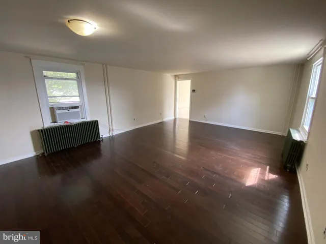 a view of room with window and wooden floor
