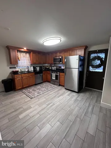 a kitchen with a refrigerator sink and wooden cabinets