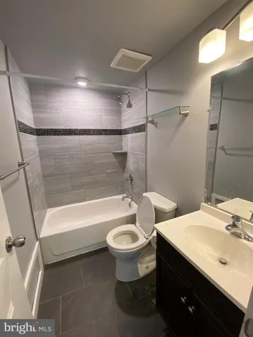 a bathroom with a sink a toilet a mirror and shower