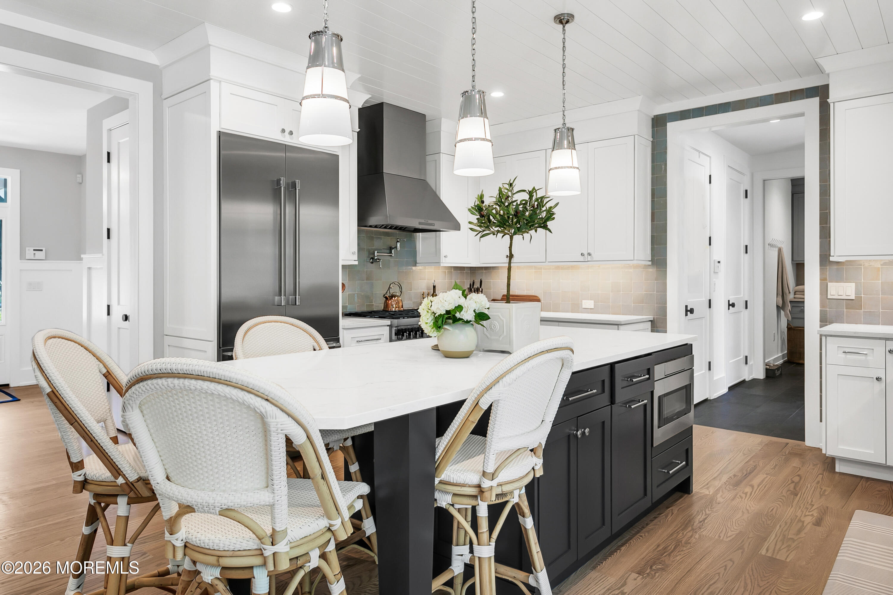 61 Center Street Rumson, NJ 07760 - Photo 3 of 30 a kitchen with stainless steel appliances kitchen island granite countertop a dining table chairs and a refrigerator