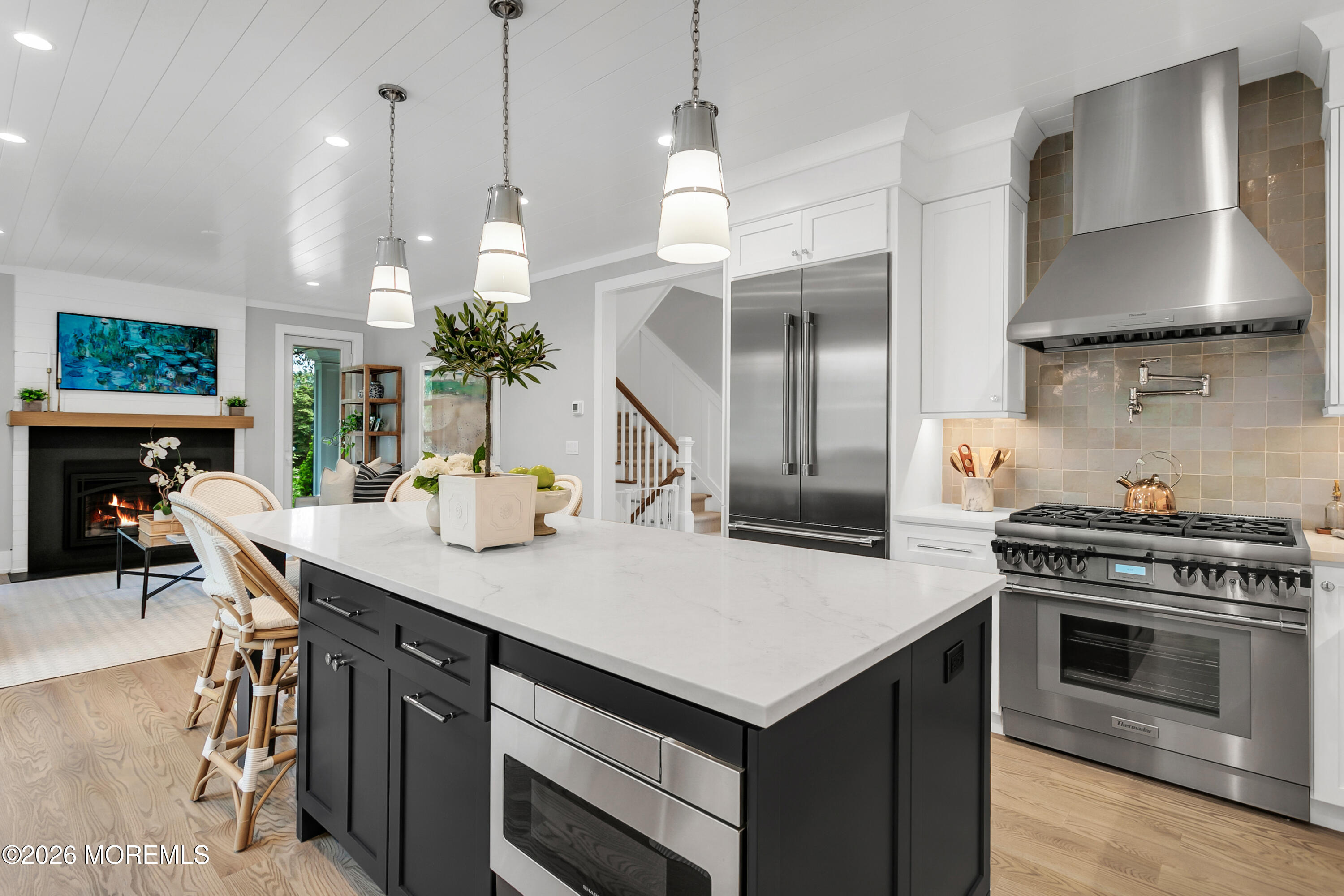 61 Center Street Rumson, NJ 07760 - Photo 5 of 30 a kitchen with a stove a kitchen island a dining table and chairs