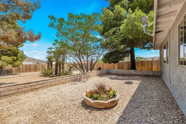 a view of a patio with table and chairs with wooden floor and fence